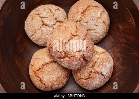 Fresh baked ginger snap cookies with cracked crumbly texture in wooden bowl. Top view. Stock Photo