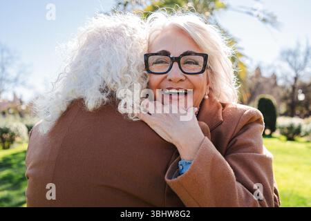 A touching moment where two seniors express their affection through a warm embrace, radiating joy and love in a delightful display of companionship Stock Photo