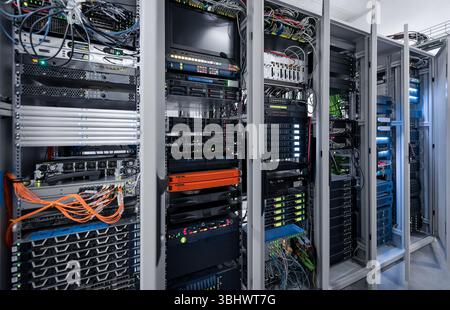 Six server racks with opened doors. Server room with numerous computers and routers. Data center. Stock Photo