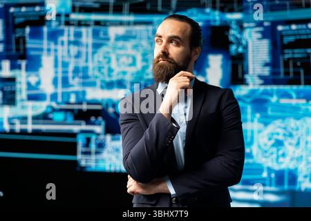 Young businessman studies artificial intelligence neural network on dashboards, using high tech automation tools for coding, analytics and machine learning for strategic development. Stock Photo