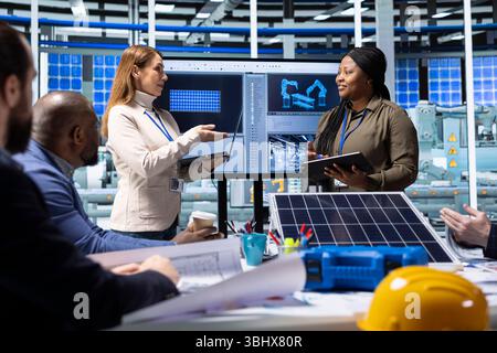 Engineers and scientists collaborate on solar panel research and development, analyzing data and experimenting with advanced materials to develop innovative renewable energy solutions Stock Photo