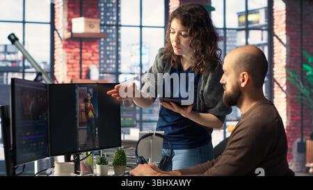 Man and woman collaborate on content creation for the media industry, analyzing data and insights, editing video footage and adjusting branding elements. AI powered. Camera B. Stock Photo