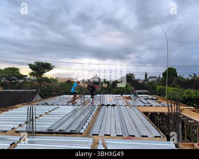 A construction worker is cutting zinc plates for the concrete base of the second floor of a building Stock Photo