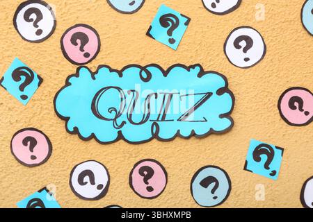 Word QUIZ in speech bubble with question marks on orange background Stock Photo