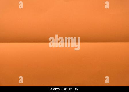 Folded orange color paper for background. Stock Photo