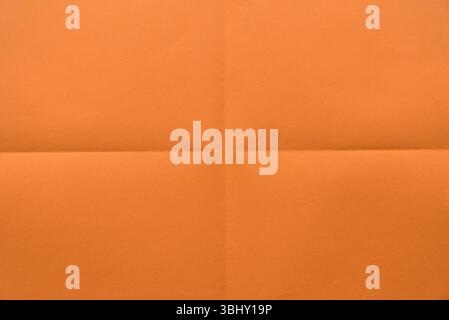 Folded orange color paper for background. Stock Photo