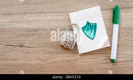 Combination Lock, Shield Drawing, and Green Pen on Graph Paper Notebook Stock Photo