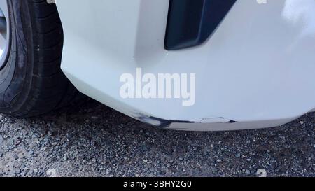 Damaged Rear Bumper of White Car with Visible Scratches and Scuffs Stock Photo