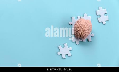 Human Brain Model on Scattered Jigsaw Puzzle Pieces Stock Photo