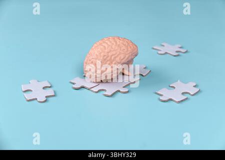 Human Brain Model on Scattered Jigsaw Puzzle Pieces Stock Photo