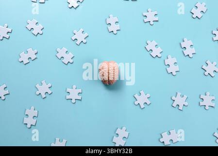 Human Brain Model on Scattered Jigsaw Puzzle Pieces Stock Photo