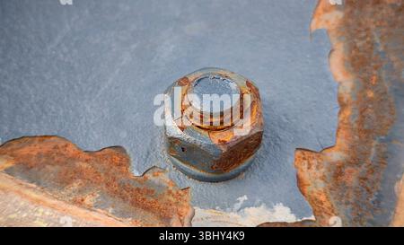 Close-Up View of a Rusty Bolt and Nut on Painted Metal Surface Stock Photo