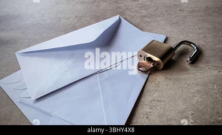 An open envelope and open metallic padlock. Email security concept. Stock Photo