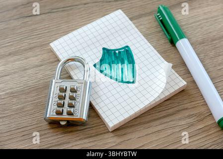 Combination Lock, Shield Drawing, and Green Pen on Graph Paper Notebook Stock Photo