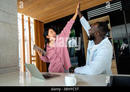 Man and woman working remotely using laptop. Male female freelancers working together. Digital nomad Stock Photo