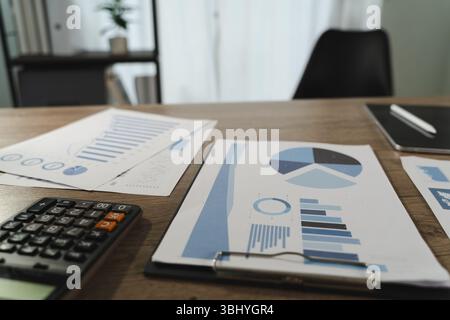 A report file image shows desk with financial documents, charts, calculator, and notebook, indicating work or analysis environment with focus data Stock Photo
