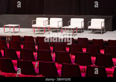 Conference hall. Auditorium full of chairs illuminated by red light Stock Photo