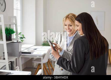 Business people looking at tablet monitor screen discussing job project in office Stock Photo