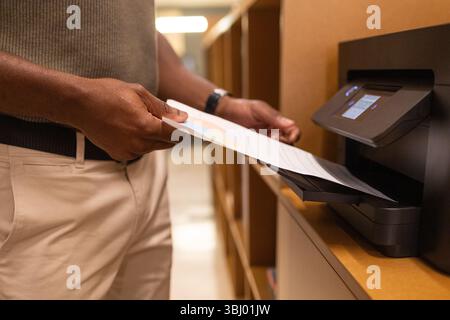 A professional in a coworking space in Barcelona operates a modern wireless printer. The image captures a moment of productivity and collaboration in Stock Photo