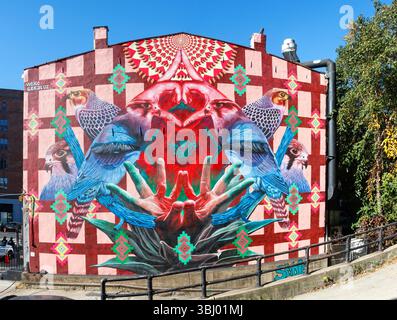 Vibrant colorful mural on building facade featuring birds geometric patterns and surreal hands,by  Aplomado Falcon by Werc and Geraluz new york city Stock Photo