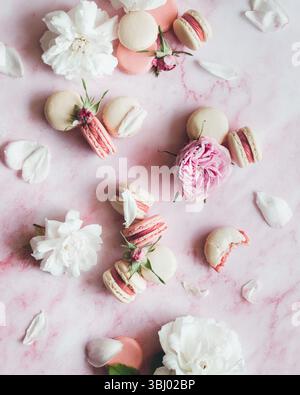 Elegant arrangement of pastel macarons and delicate pink roses on a soft pink marble surface, creating a romantic and luxurious atmosphere perfect for Stock Photo
