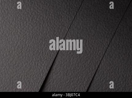 Black matte paper texture with a rough, grainy surface, featuring an organic, structured pattern. Elegant, modern design with a tactile, industrial fe Stock Photo