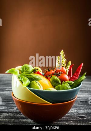 Fresh vegetables in a bowl on the table with brown background Stock Photo