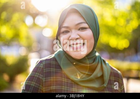 Portrait of asian muslim woman wearing hijab smiling at camera Stock Photo