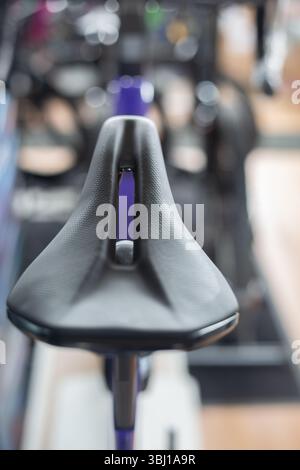 Detail of the sport saddle for bicycle. Elegant black and white racing saddle on the seat post, close-up.Racing bike. Stock Photo