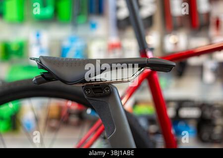 Detail of the sport saddle for bicycle. Elegant black and white racing saddle on the seat post, close-up.Racing bike. Stock Photo