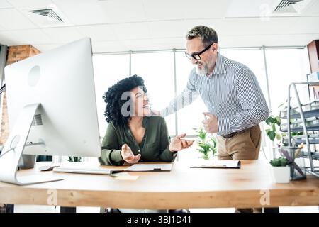 Professional coworkers engaging in a collaborative team meeting within a bright office environment Stock Photo
