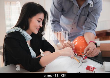 Group of two coworkers working with blueprint in office. co-working teamwork concept. Stock Photo