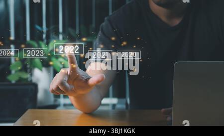 A man touching on virtual screen 2022. Business new year concept, welcome to year 2022 concept. Stock Photo