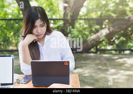 Young business woman sitting at table using laptop in coffee shop cafe. Blogging Freelancers working. Woman using laptop. Stock Photo