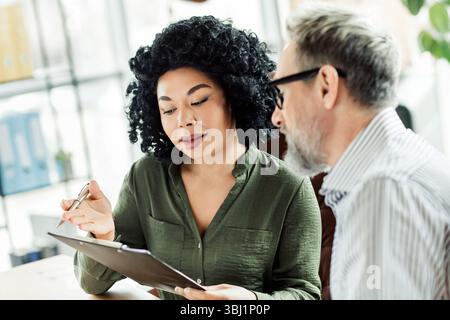 Confident colleagues discussing business projects in a bright office environment with cooperation and teamwork Stock Photo