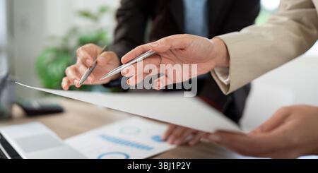 Business Strategy Discussion. Women collaborating on project details with documents. Stock Photo