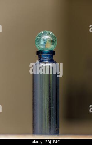 An old marble on top of a glass vial; stacked macro photography captured in a house farm in the eastern Andean mountains of central Colombia, Stock Photo