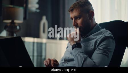Excited Financial Analyst Working on Laptop, Monitoring Real-Time Stocks, Exchange Market Charts. Successful Businessman Making Profitable Investments, Working in Comfortable Office of Investment Bank Stock Photo