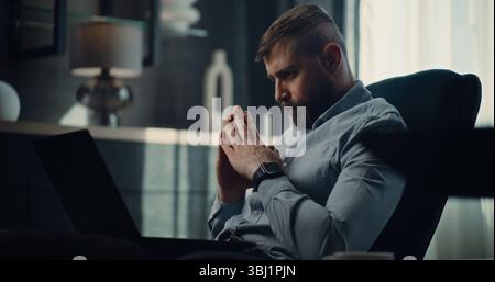 Sad Professional Stock Exchange Trader Monitoring Real-Time Stocks and Exchange Market Charts on Laptop, Suffering from Financial Crisis. Investment Agent Stressed About Sudden Stock Market Collapse. Stock Photo