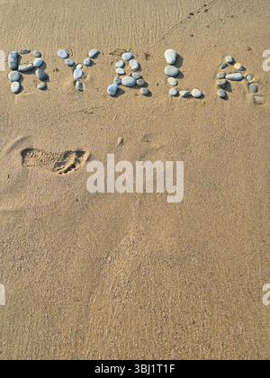 Inscription on a sandy beach laid out with stones. inscription Byala. resort town in Bulgaria Stock Photo