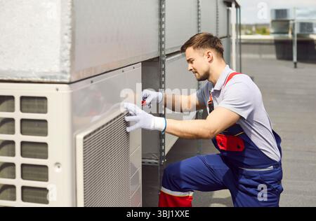 Electrician Maintaining And Repairing Hvac Ventilation System On Roof Stock Photo