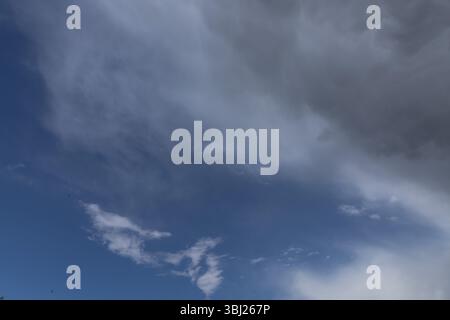 Ominous mammatus clouds form in the sky, signaling an approaching storm. The unusual pouch-like structures and dark gray tones create a powerful and e Stock Photo