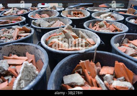 Buckets filled with broken terracotta tiles and ceramic fragments from building demolition or renovation work in Lisbon, Portugal, Europe. Stock Photo