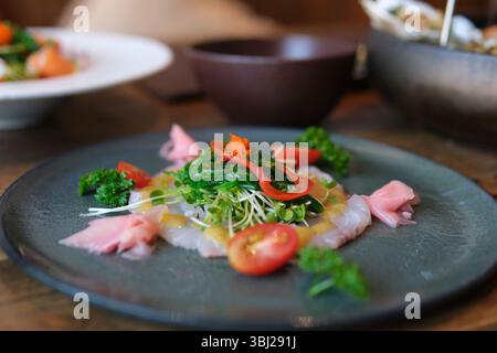 Boiled white rice with salted red fish, cucumbers and other vegetables with herbs in a plate. High quality 4k footage Stock Photo