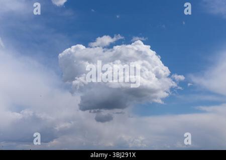 Ominous mammatus clouds form in the sky, signaling an approaching storm. The unusual pouch-like structures and dark gray tones create a powerful and e Stock Photo