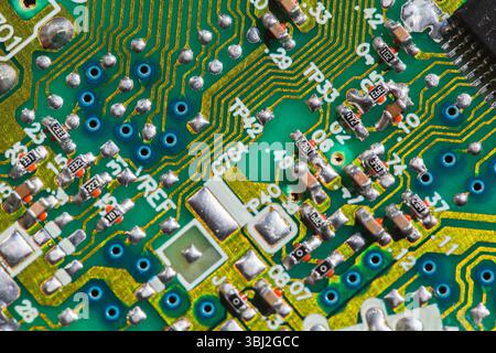 A detailed view of a green printed circuit board showcasing electronic pathways, traces, and components used in technology and engineering application Stock Photo
