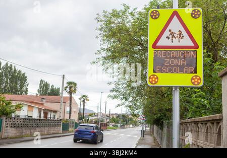 Signpost equipped with school warning message system. Spanish language: Warning school area Stock Photo