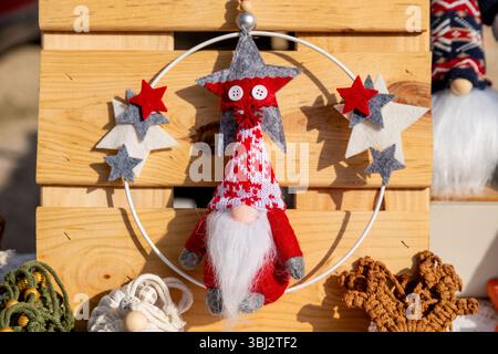 Denia, Alicante - Spain - 12-01-2024: A handmade festive gnome decoration with a red and white knitted hat, white beard, and surrounding felt stars, d Stock Photo