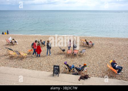 People relaxing in deckchairs, Marine Parade, Sandy Beach, Lyme Regis, Dorset, England, United Kingdom Stock Photo