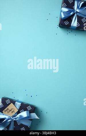 Happy Father's Day concept. Gift boxes with blue ribbons and greeting tag on a blue background. Flat lay composition with copy space, ideal for holida Stock Photo